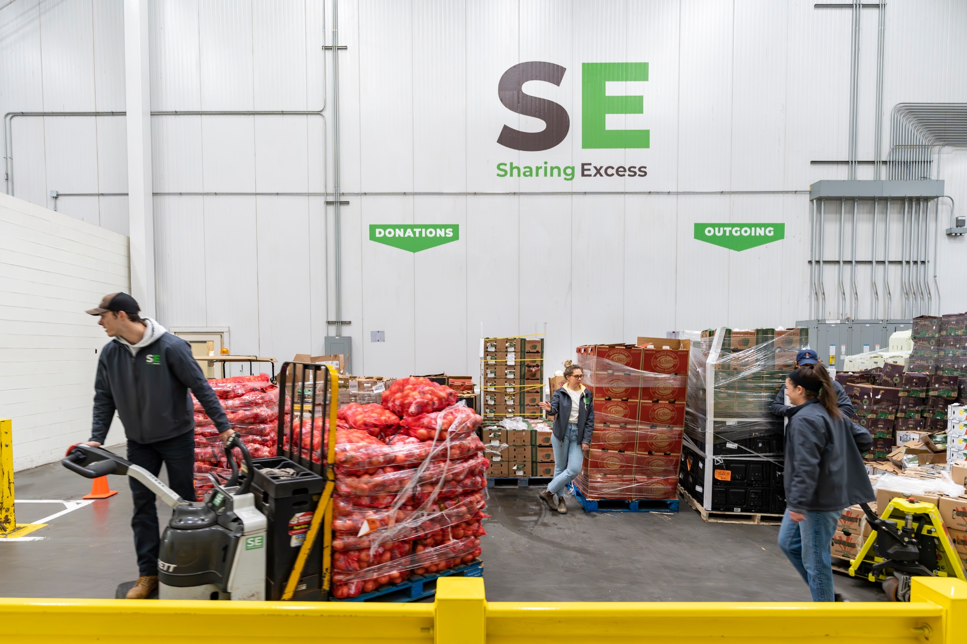 Sharing Excess team moving pallets of rescued produce inside the warehouse